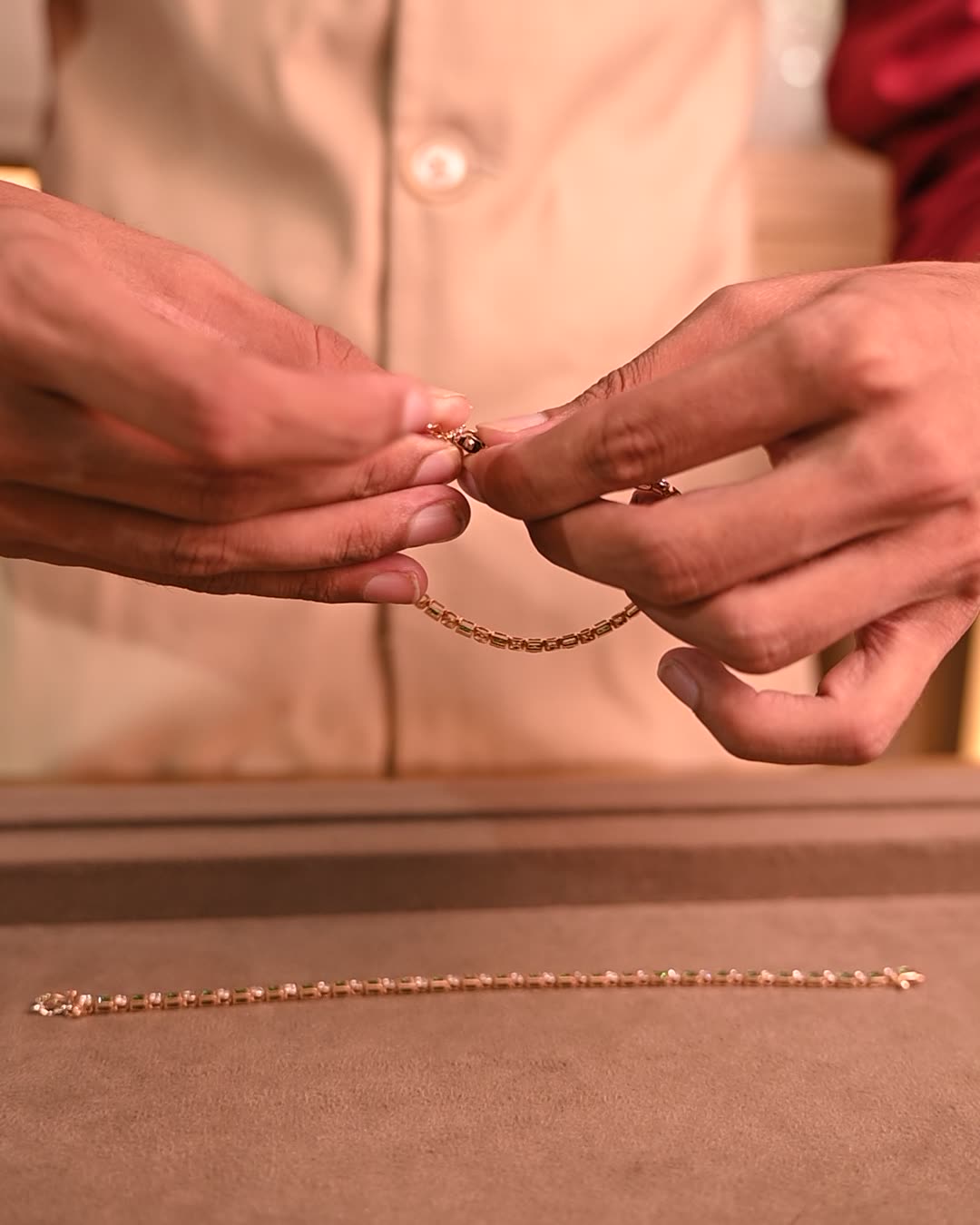 A finished gold bracelet being checked by hand